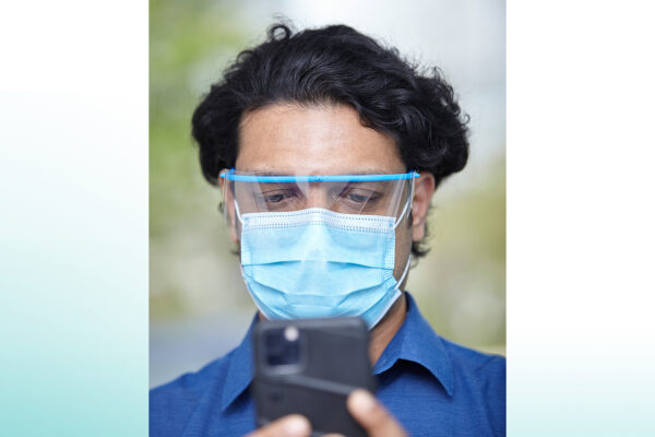 Man Wearing Face Shield and Mask texting