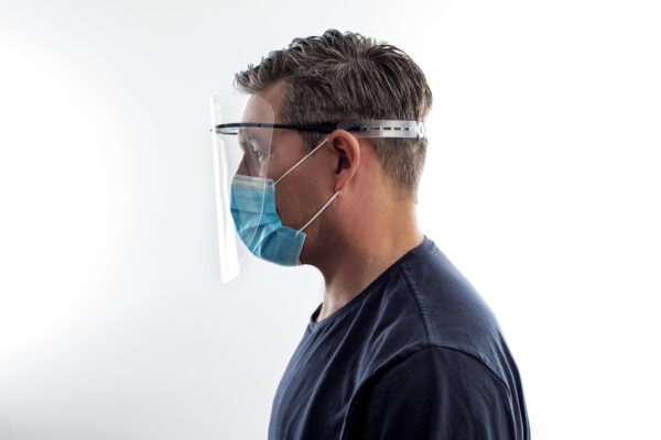 Man Wearing Face Shield and Mask from side profile.